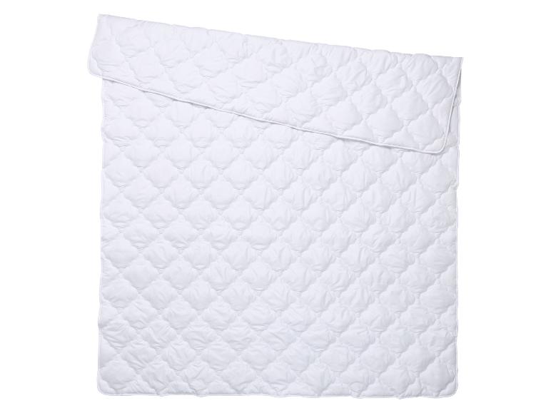 Wit gewatteerd dekbed, opgevouwen, met ruitpatroon.