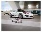 Een witte Porsche 911 GT3 en een kleiner puzzelmodel voor een modern gebouw.