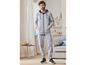 Man in een grijze hoodie en joggingbroek van Puma.