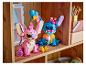 Twee Lego Stitch en Angel figuren op een houten plank, met accessoires.