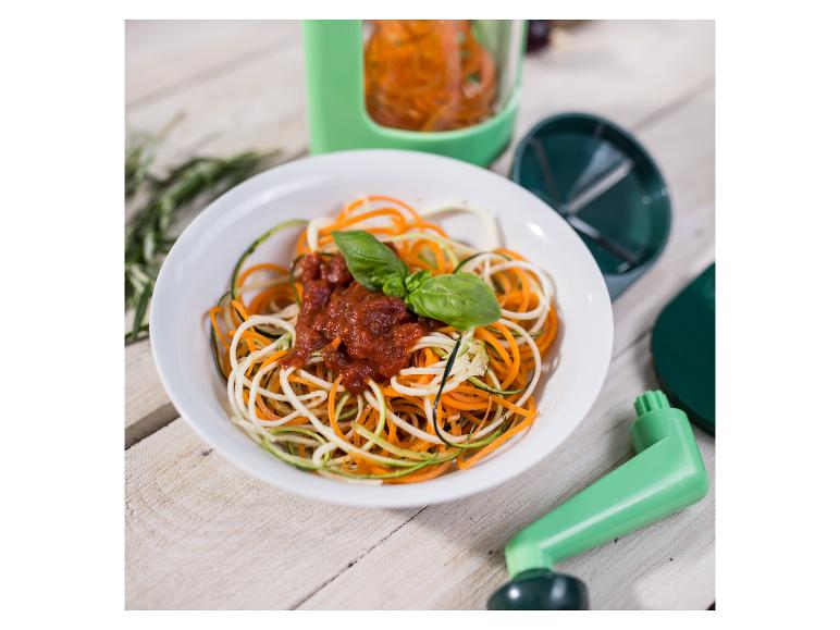 Groentennoedels met tomatensaus en basilicum, naast een spiraalsnijder.