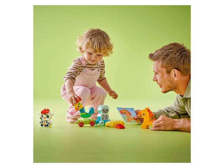 Kind en volwassene spelen met kleurrijke bouwblokken op een groene achtergrond.