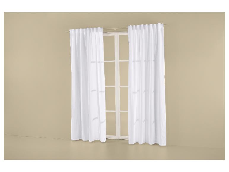 Transparante witte gordijnen aan een gordijnroede, voor een raam met witte kozijnen.