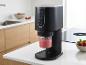 Zwarte ijsmachine met aardbeiensmoothie in een moderne keuken.
