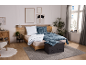 Gezellige slaapkamer met houten bed, blauw geruit beddengoed en grijs vloerkleed.