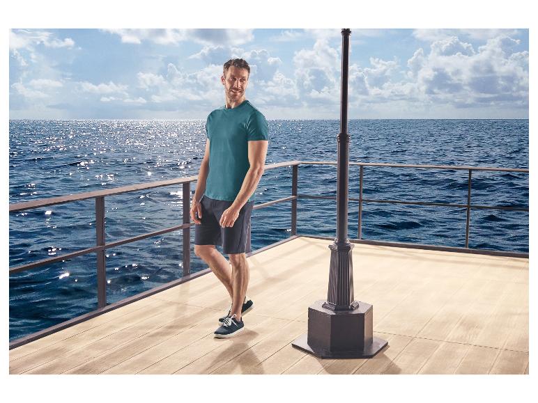 Man in t-shirt en korte broek, draagt ESMARA MEN vrijetijdsschoenen, op een pier.