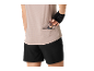 Vrouw in sportshirt en korte broek, haalt een energiereep uit de achterzak.