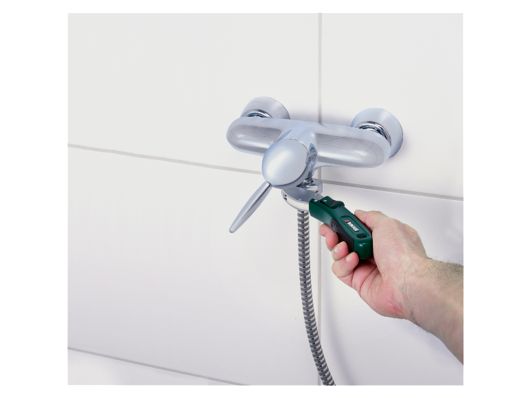 Een man gebruikt een Parkside sleutel om een douchekraan te repareren.