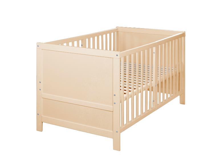 Licht houten babybedje met spijlen op een witte achtergrond