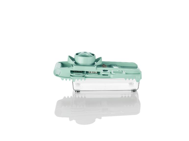 Een groene snijder met opvangbak voor groenten en fruit.