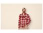 Man in rood geruit overhemd, beige muts en broek.