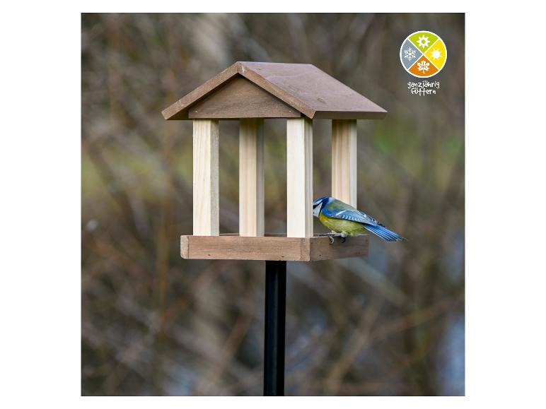 Vogelvoederhuisje met pimpelmees en logo voor jaarrond voeren.