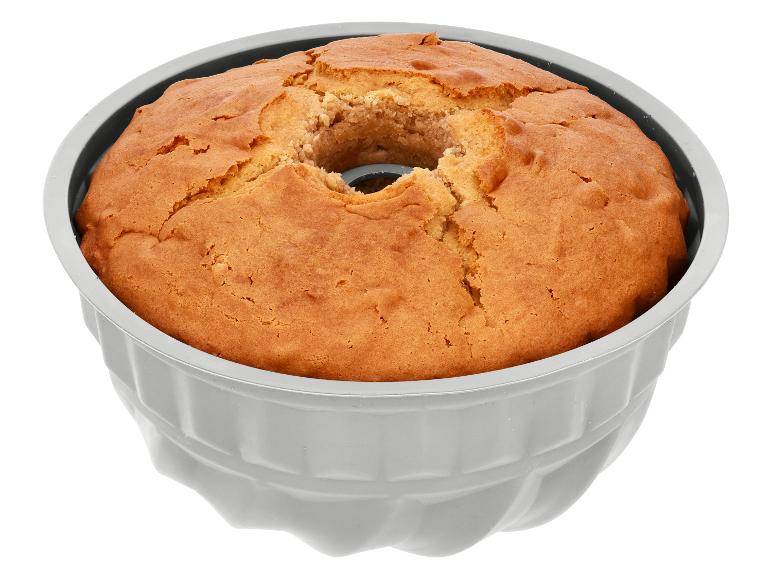 Versgebakken gouden Bundt cake in een grijze vorm