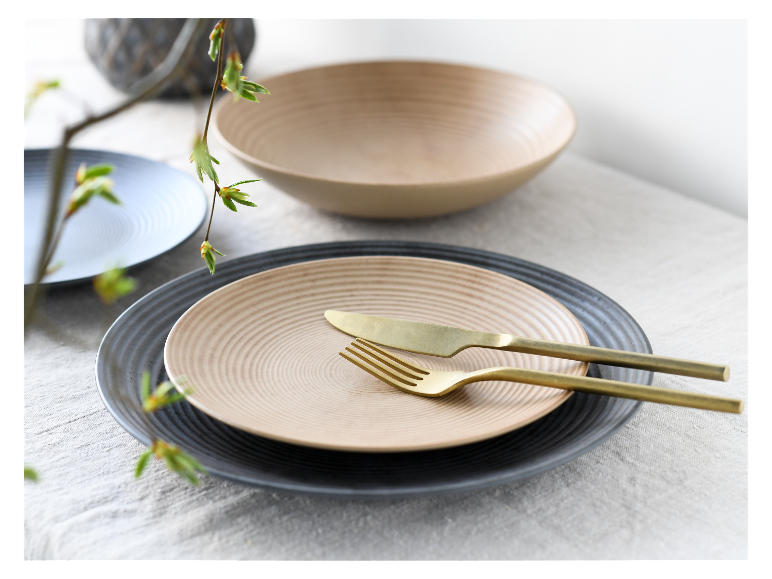 Chique servies: beige en grijze borden, beige schaal, gouden bestek.