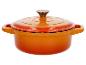 Oranje gietijzeren pan met deksel.