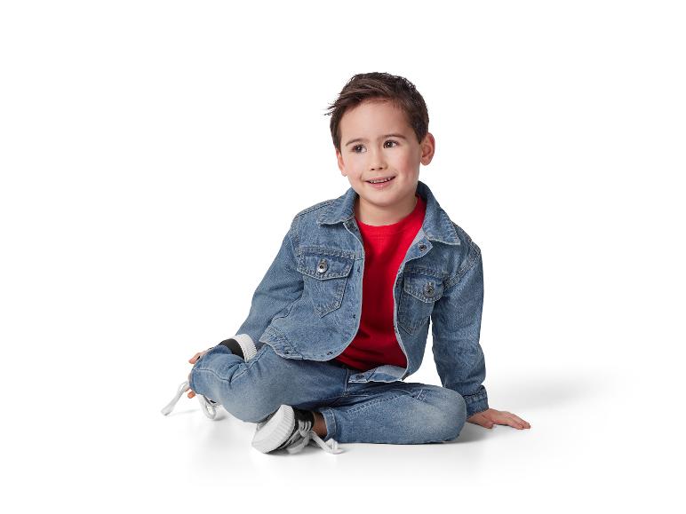 Lachend kind in jeans en spijkerjasje.