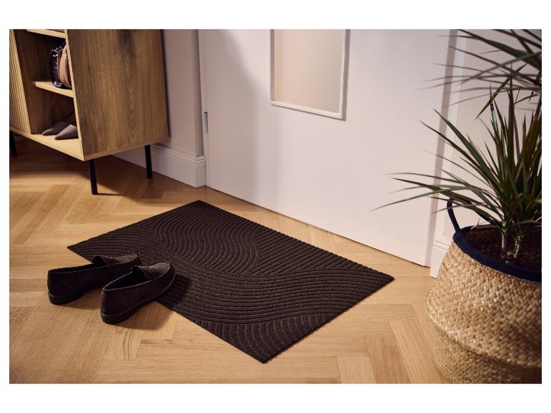 Bruine LIVARNO® droogloopmat met golfpatroon bij de deur.