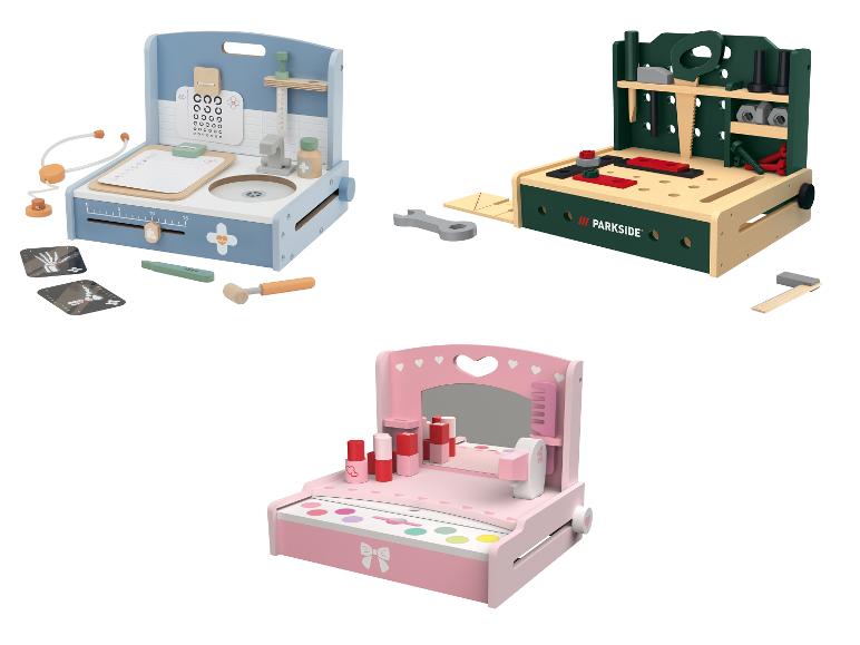 Drie houten speelsets: een dokterspraktijk, een werkbank en een kaptafel.