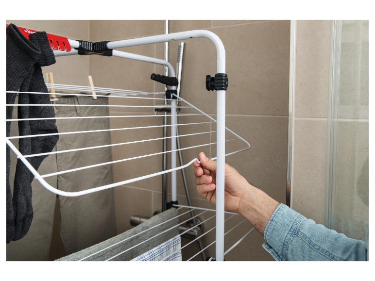 Wasrek met kleding, waaronder sokken en broeken, in een badkamer.