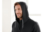 Een man draagt een zwarte hoodie met een rits.
