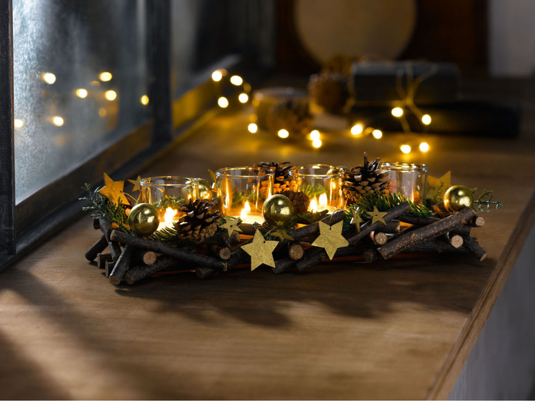 Een kerstkrans met brandende kaarsen, dennenappels en sterretjes.