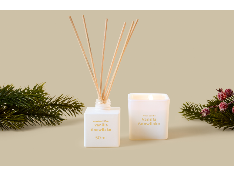 Kerstkaars en diffuser met vanille sneeuwvlokgeur, met dennentakken.