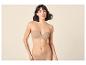 Vrouw in een huidkleurige strapless beha en slip.