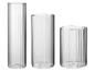 Drie cilindrische glazen vazen met verticale ribbels.