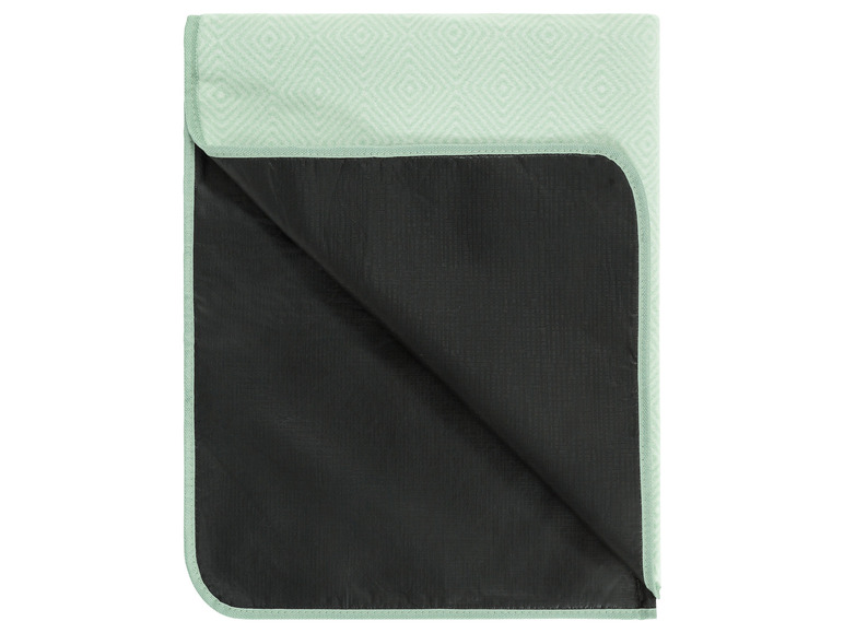 Een gevouwen picknickdeken met een groene, geometrische print.