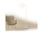 Witte vloerlamp verlicht beige fauteuil in minimalistisch interieur.
