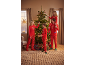 Een gezin in bijpassende rode kerstpyjama's versiert een kerstboom.