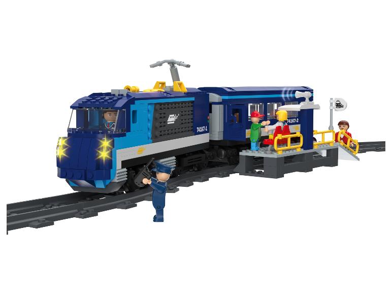 Blauwe speelgoedtrein met rails, een perron en figuren, op een witte achtergrond.