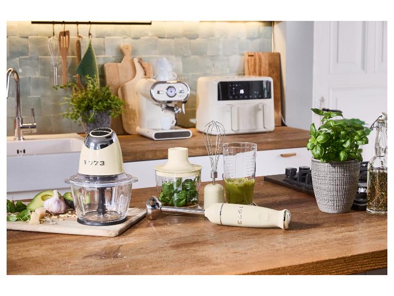 Retro keukenapparatuur: minihakker, staafmixer en andere accessoires op een houten tafel.