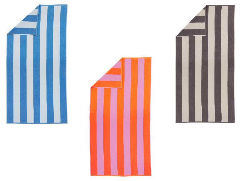 Drie gestreepte strandlakens in de kleuren: blauw en wit, oranje en roze, en grijs en crème.