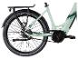 Achteraanzicht van een lichtgroene elektrische fiets met riemaandrijving en bagagedrager.