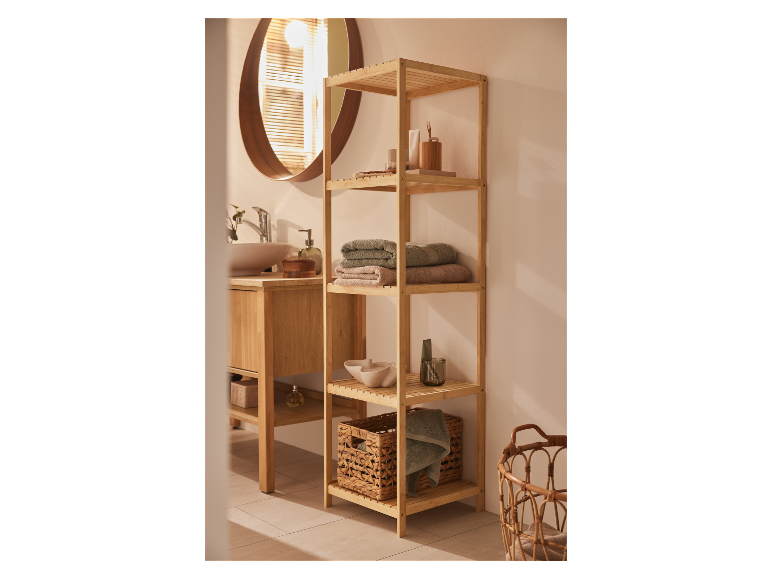 Een bamboe plank met handdoeken en badkameraccessoires in een moderne badkamer.