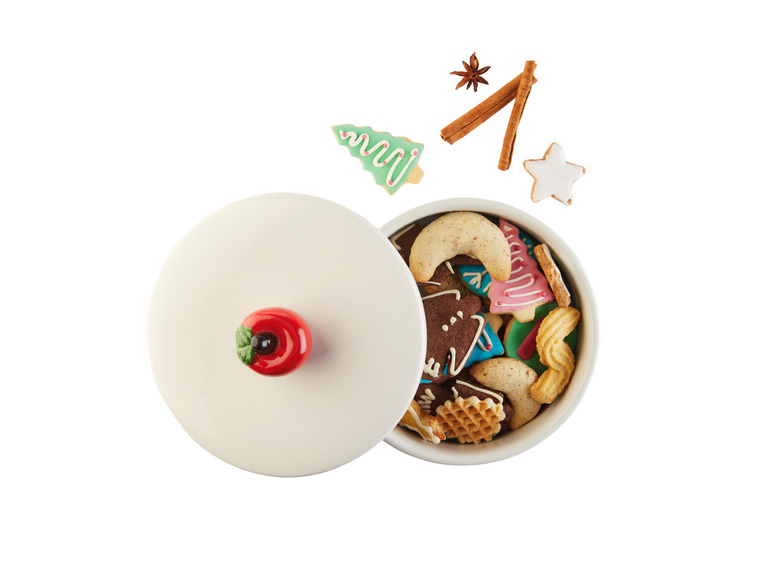 Kerstkoekjes in een witte pot met een rode appelknop