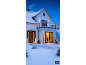 Huis in de winter met kerstverlichting, inclusief slingers, kerstbomen en een verlicht hert.
