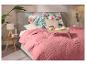 Slaapkamer met een roze sprei, kussens met bloemenpatroon en een houten ontbijtblad.