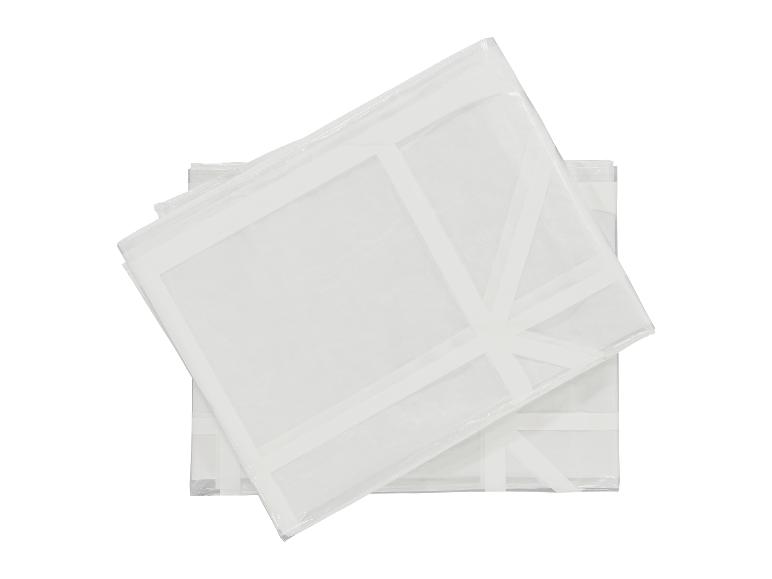 Twee witte, transparante kledinghoezen, op elkaar gestapeld.