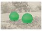 Twee groene bolvormige tuinlampen in een tuinomgeving.