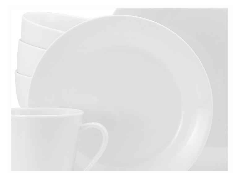 Close-up van een wit servies met borden, kommen en een mok.