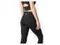 Vrouw in zwarte sporttop met uitsnede en zwarte high-waist leggings.