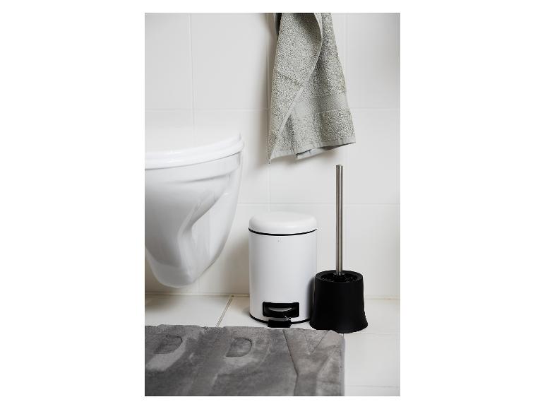 Badkameraccessoires: witte prullenbak en zwarte toiletborstelhouder.