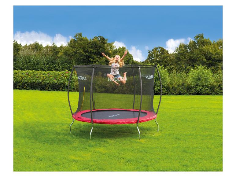 Blond meisje springt op een rood-zwart Hudora trampoline in een groene tuin.