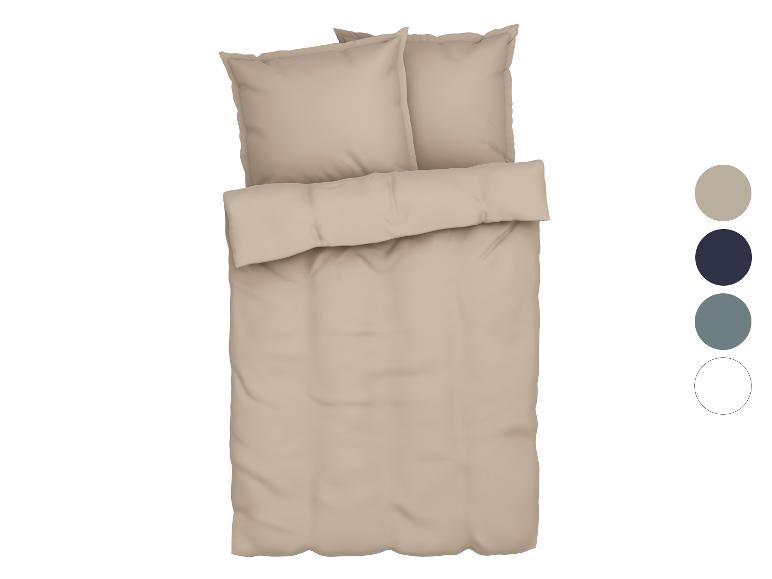 Beige beddengoed met bijpassende kussens en kussenslopen.