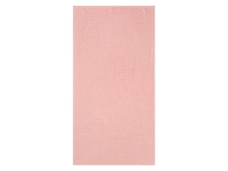 Lichtroze badhanddoek met textuur.
