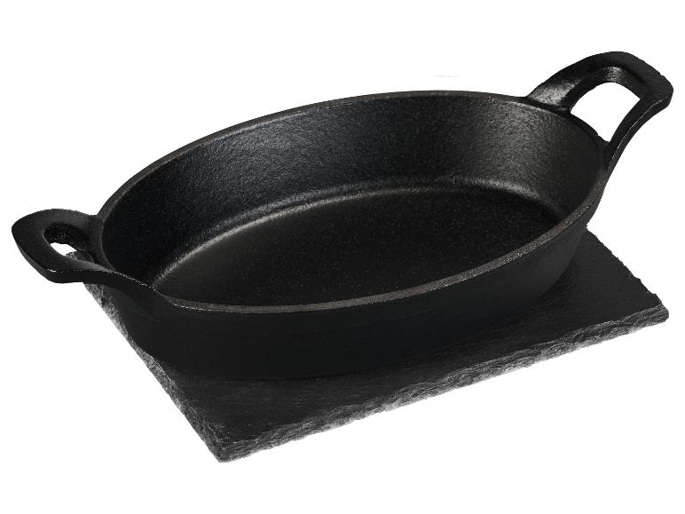 Ovale gietijzeren serveerpan op een stenen onderzetter