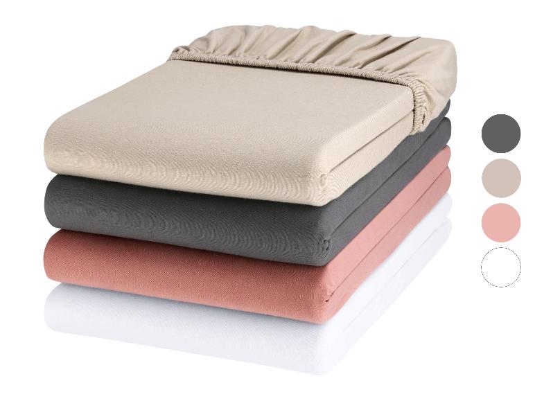 Drie matrasbeschermers in neutrale kleuren.