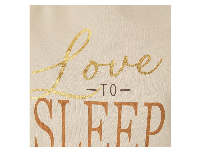 Close-up van een crèmekleurige top met goud- en bruine opdruk met de tekst 'Love to Sleep'.